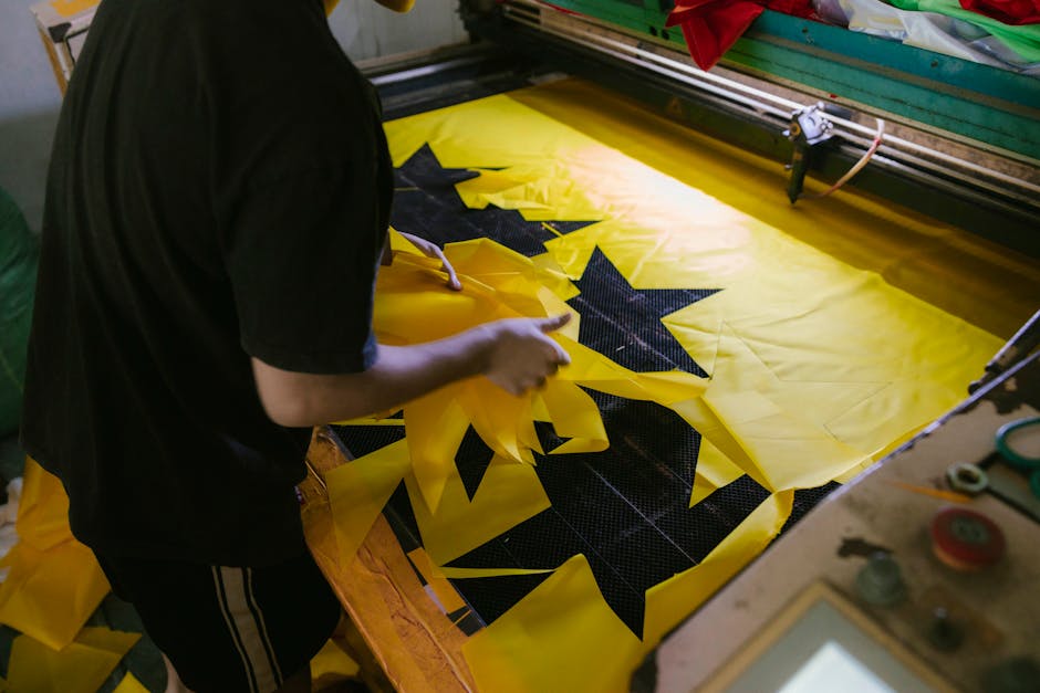 A person arranging bright yellow fabric with star patterns. Ideal for festival and craft themes.