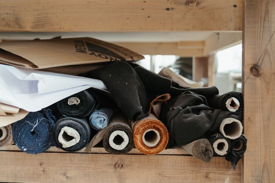 Close-up of diverse fabric rolls neatly arranged in an artisanal workshop setting.